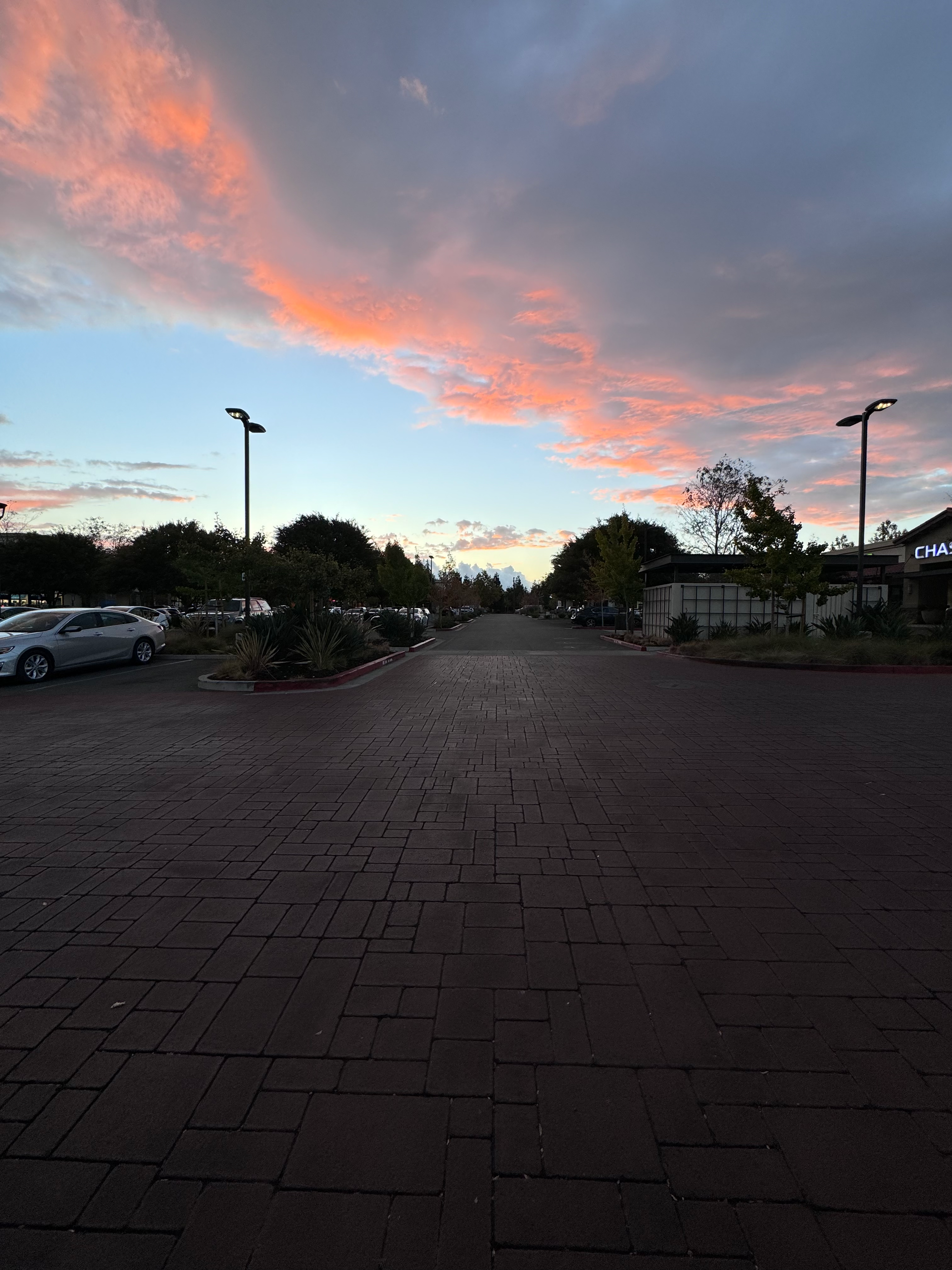 Parking lot at dusk with pink and grey clouds