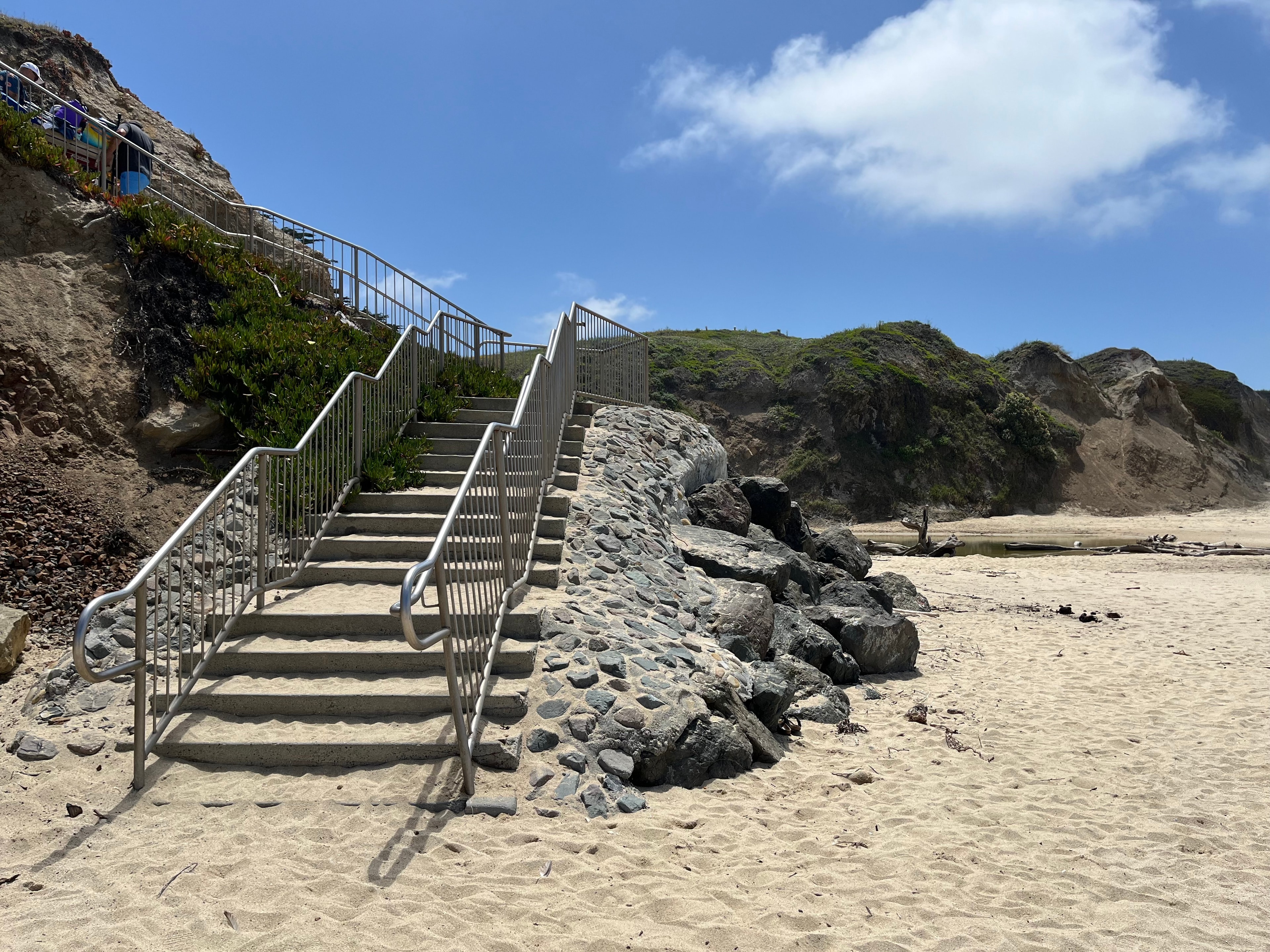 Beach stairway descending sandy coastal cliffs to the shore