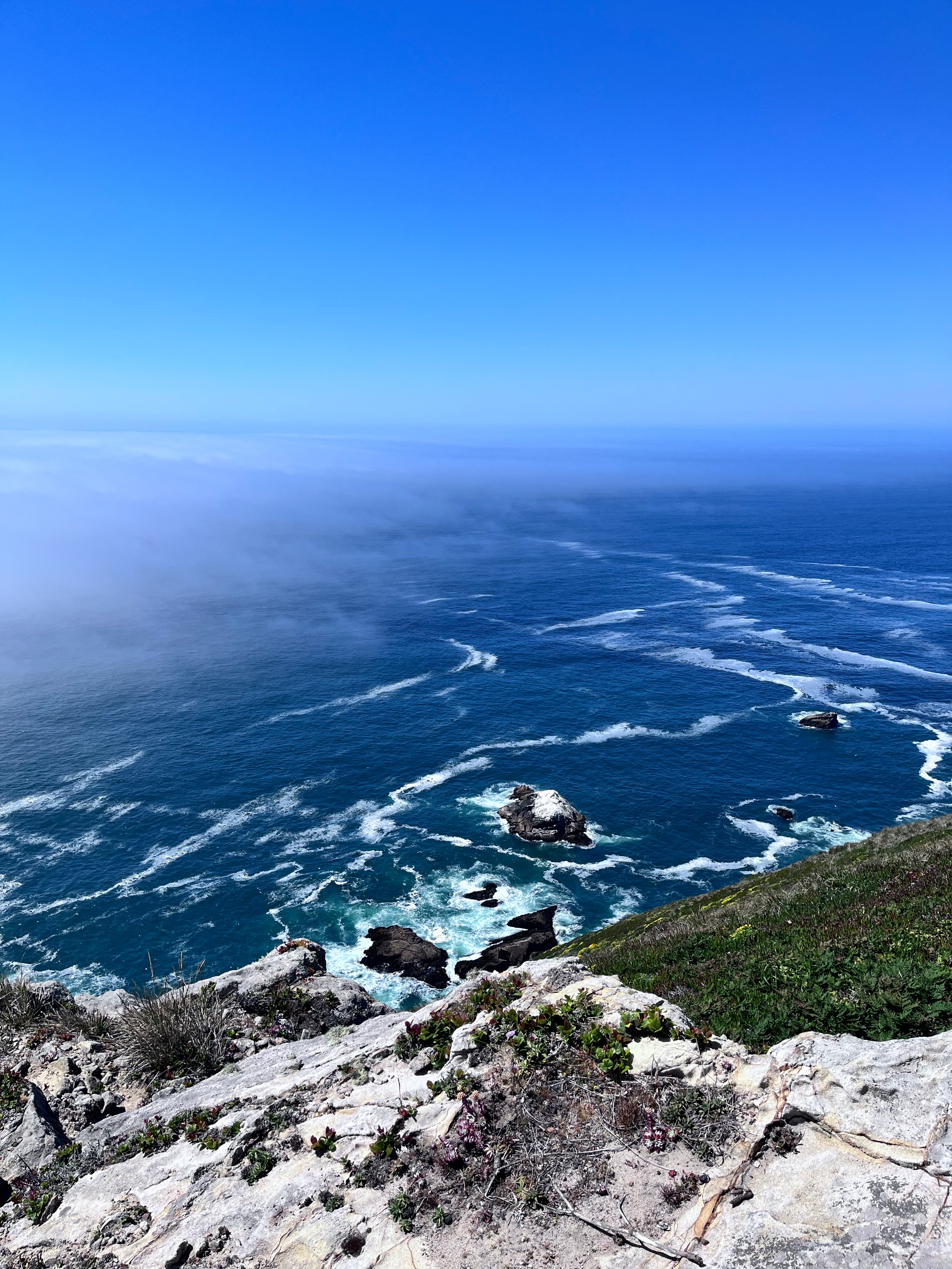Rugged Big Sur coastline with turquoise ocean and rocky cliffs under vivid blue sky